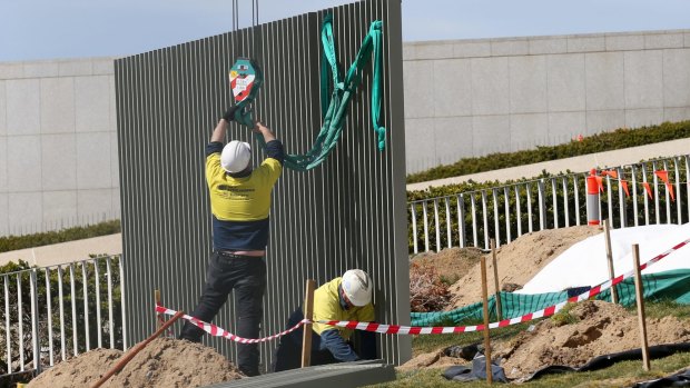 The security fence is installed across the lawns of Parliament House in Canberra.
