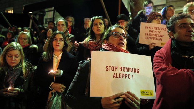 People hold poster and candles during a gathering in Paris on Wednesday.