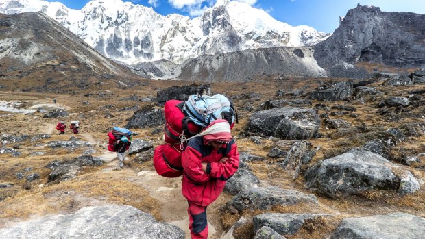 Porters with heavy loads after crossing Cho La Pass.