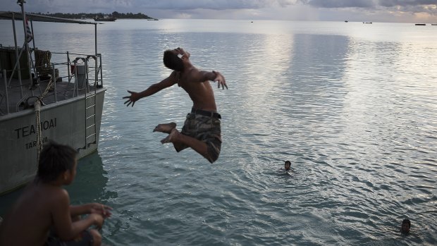 Local I-Kiribati youth jump off the Betio jetty in the late afternoon.