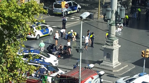 Injured are helped by responders after a white van jumped the sidewalk in the historic Las Ramblas district of Barcelona.