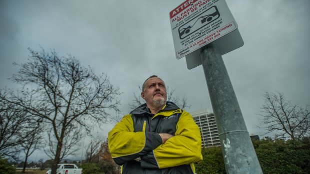 Wilson Parking enforcement officer Graham Bell and the signs installed to encourage people to pay for parking and parking fines.