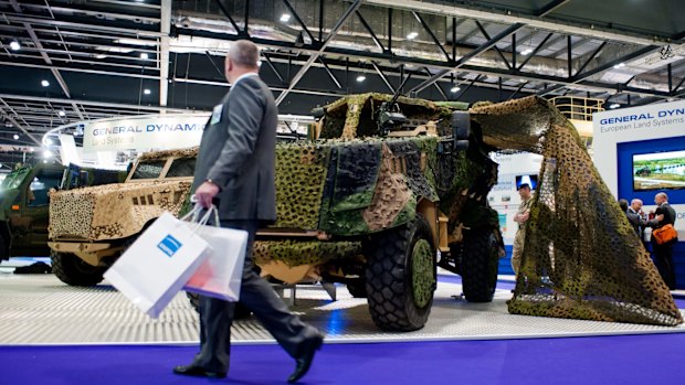 A visitor walks past the General Dynamics pavilion during the 2013 edition of the DSEI arms fair in London.