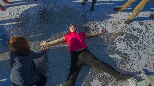 Performing a coin angel rather than a snow angel, Connie Johnson said she felt overwhelmed by the generosity of the Canberra community.