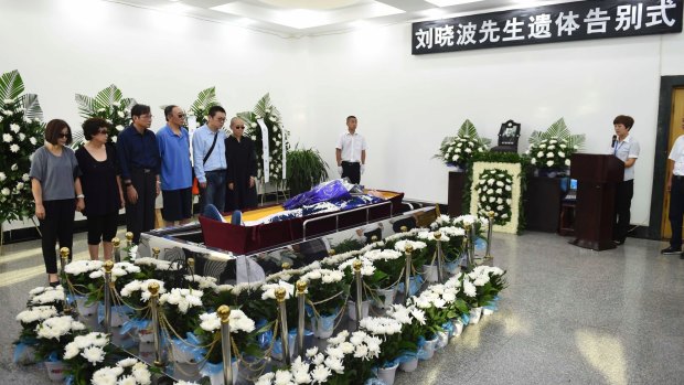 Relatives stand next to the casket of Chinese dissident Liu Xiaobo during his funeral on Saturday.