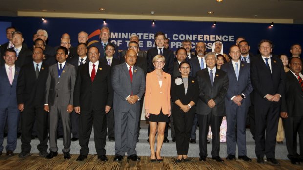 Heads of delegations pose for a photograph during the opening of the Bali Process regional ministerial meeting.