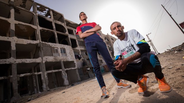 Nader al-Masri (right) and Anas al-Masri  outside a building destroyed by Israeli bombardment in the Gaza Strip town of Beit Hanoun.