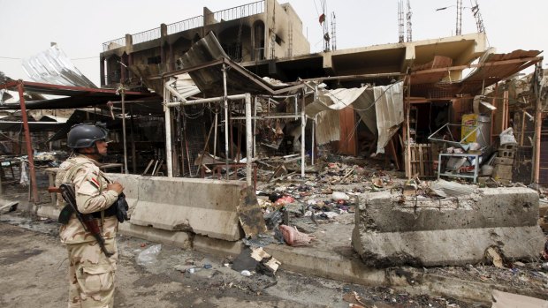 A member of the Iraqi security forces looks at the site of the Khan Bani Saad attack.