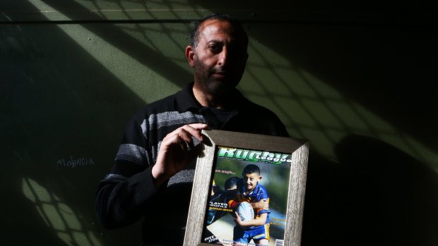 Azzam Hrouk, father of Mahmoud Hrouk, poses with a picture of his murdered son. 