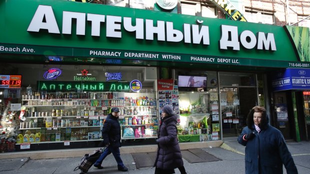 People walk past a pharmacy that caters to the Russian community in Brooklyn, New York. Russian-speaking expatriates in the city have shrugged off accusations that Kremlin hacking helped sway the presidential election.
