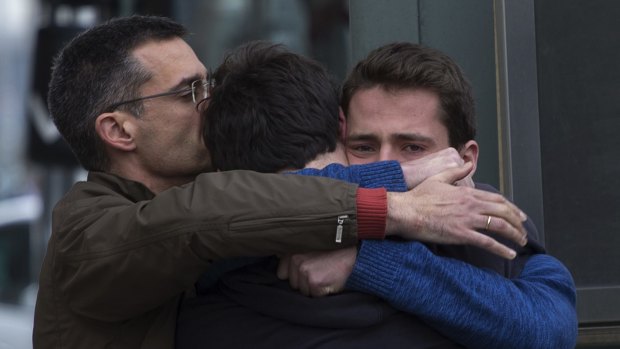 Family members of people involved in the Germanwings plane crash comfort each other as they arrive at Barcelona airport in Spain.