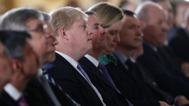 Britain's Foreign Secretary Boris Johnson, centre, listens to the speech.