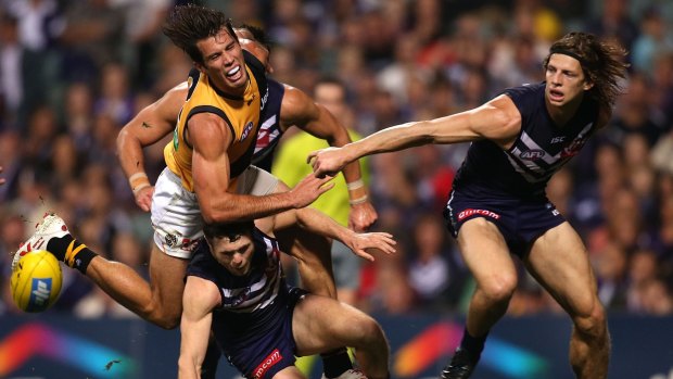 Alex Rance of the Tigers crashes into Hayden Ballantyne of the Dockers as Nat Fyfe watches.