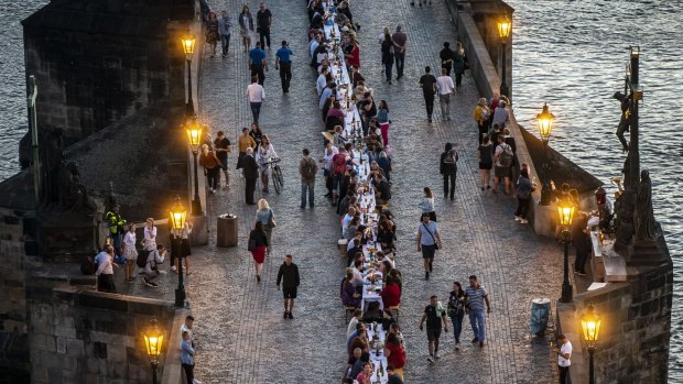 Residents dine on a 500-metre-long table set on the Charles Bridge, after restrictions were eased.