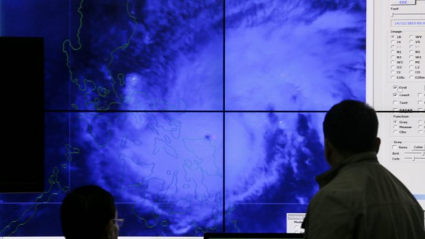 Government meteorologists look at a satellite image of Typhoon Melor in the weather bureau centre in suburban Quezon city, northeast of Manila.