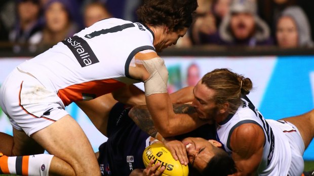 Michael Walters of the Dockers is taken to ground by Phil Davis and Matt Buntine of the Giants.