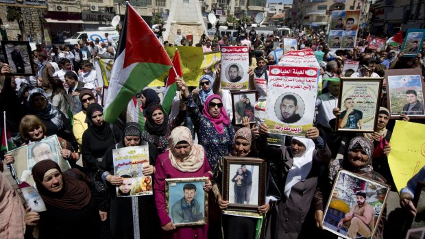 Relatives of Palestinians held in Israeli jails hold their portraits during a protest to mark Prisoners' Day in the West Bank city of Ramallah on Sunday. 