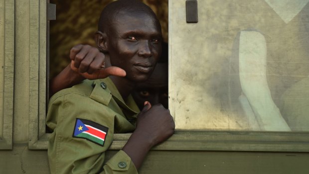 A rebel with the South Sudanese flag on his uniform on a bus bound for a camp on the outskirts of Juba as part of the peace deal with the government.