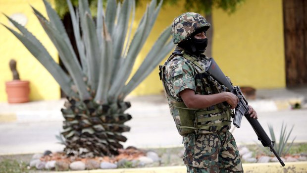 A Mexican Marine stands guard during a search operation to locate Guzman, in Mazatlan on Wednesday.