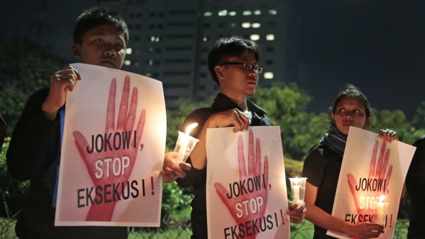 Activists hold posters which read "Jokowi, stop the executions" during a candlelight vigil outside the presidential palace in Jakarta last year.