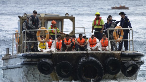 Australian Customs officials and navy personnel escort asylum seekers to Christmas Island.
