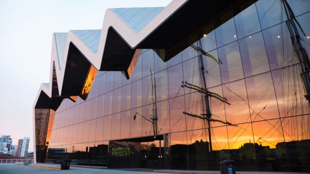 The Riverside Museum in Glasgow. Reflected in the glass facade are the masts of the Victorian tall ship Glenlee.