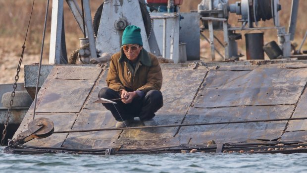 A North Korean man fishes off a ferry in Sinuiju near the Chinese border.