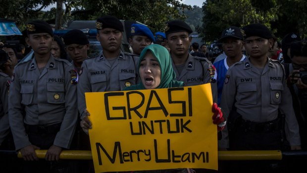 A protester holds a banner during a demonstration against the death penalty of death row prisoner Merry Utami at Wijayapura port, the entrance gate to Nusakambangan prison, on Thursday.