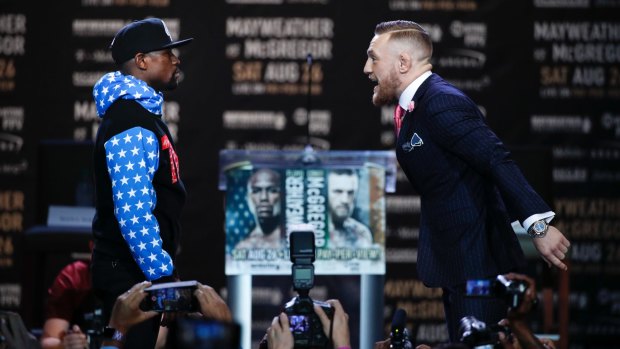 Turn up: Conor McGregor taunts Floyd Mayweather jnr at a press conference for their August bout.