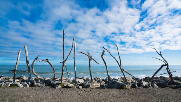 Hokitika's beach is littered with enormous driftwood, much of which has been stacked into an ad-hoc outdoor art gallery.