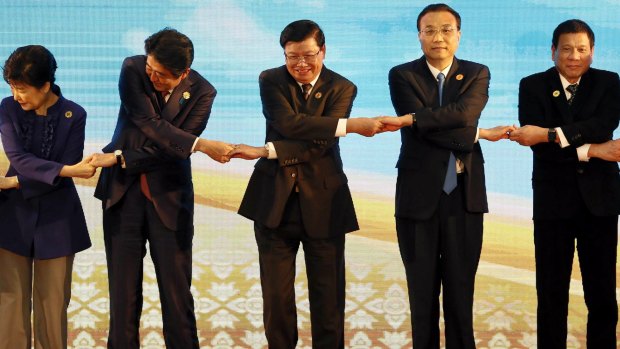 From left to right: South Korean President Park Geun-hye, Japanese PM Shinzo Abe, Laos' PM Thongloun Sisoulith, Chinese PM Li Keqiang, and Philippine President Rodrigo Duterte, link arms during the ASEAN Aummit.
