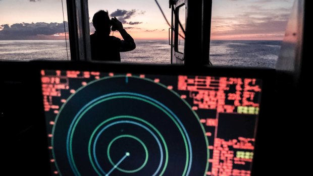 A Sea Watch crew member scans the horizon at dawn for migrant boats in the central Mediterranean Sea last week.