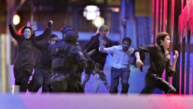 Hostages flee from the Lindt cafe in Martin Place during the early hours of December 16, 2014.