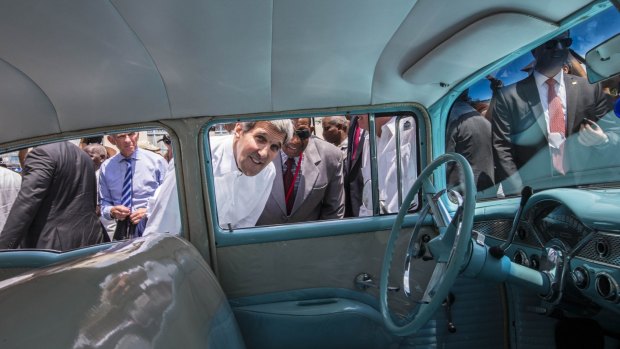 John Kerry looks into the interior of a classic American car parked in Old Havana, Cuba.