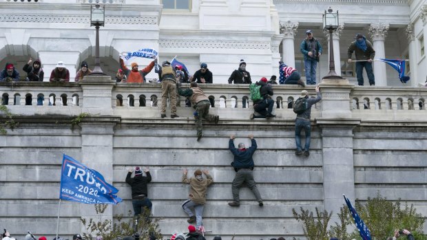 Supporters of President Donald Trump scale the west wall during the attack on the US Capitol in Washington on January 6.