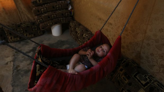 Syrian refugee Abdelkrim Mahmoud sleeps on a hammock in a tent at a Syrian refugee camp in  Deir Zanoun, Lebanon. 