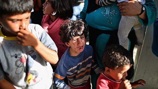  A young boy cries as refugees board trains and buses at the train station in Beli Manastir, Croatia, near the Hungarian border on Friday.