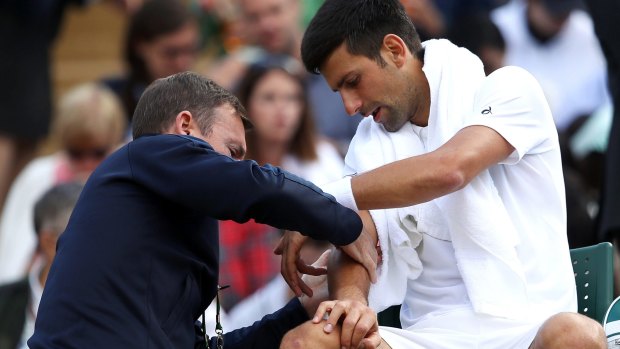 Novak Djokovic receives treatment on his injured elbow during his Wimbledon quarter-final.