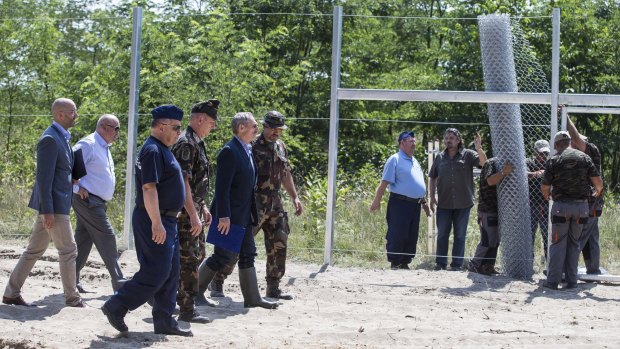 Hungarian ministers inspect the first portion of the fence.