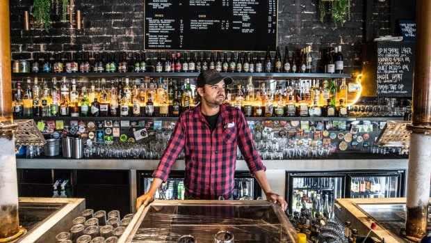 Roshan Nijar, co-owner of Up In Smoke, stands behind his bar.