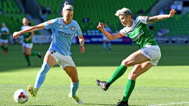 Michelle Heyman of United (right) strikes the ball past Alanna Kennedy of City during the round 7 W-League match between Melbourne City and Canberra United.