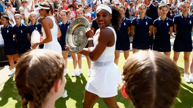 Check out what I won: Serena Williams leaves court with the Venus Rosewater Dish after her Wimbledon victory.