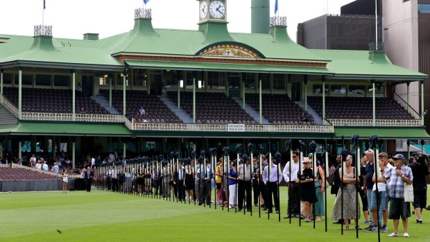 Tribute: Crowds observe 63 bats featuring images from Phillip Hughes' career prior to the memorial service for the former NSW and Test batsman.