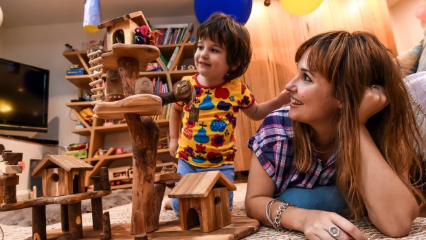 Three-year-old Leo Colosimo having fun with some traditional toys as mum Kristy Biagini looks on.