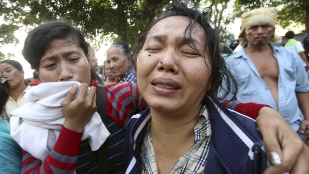 Family members cry outside at Adam Malik hospital as they wait for the bodies of victims of an Indonesian military C-130 Hercules transport plane that crashed into a residential area in the North Sumatra city of Medan, Indonesia.