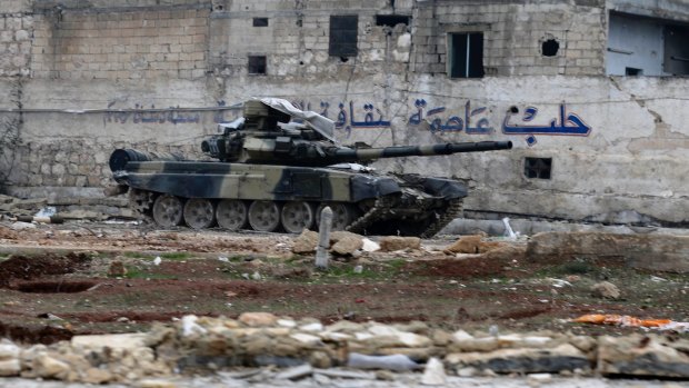 A Syrian army tank is seen in front of a wall bearing the legend "Aleppo is the capital of culture" in the east Aleppo neighborhood of Tariq al-Bab.