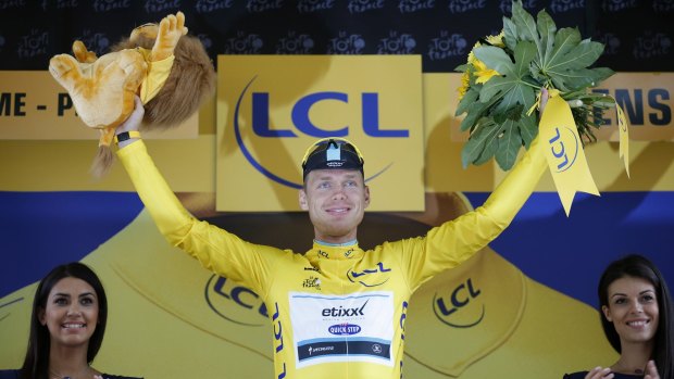 Germany's Tony Martin, wearing the overall leader's yellow jersey, celebrates on the podium of the fifth stage of the Tour.