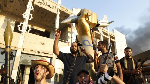 Rebels take the Libyan dictator's compound at Bab al-Aziziya in Tripoli in August 2011. The statue of a plane and fist commemorated the US bombing of the compound in 1986.