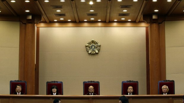Park Han-chul, centre, president of South Korea's Constitutional Court, sits with other judges before the judgment at the Constitutional Court in Seoul.