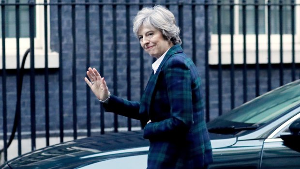 Theresa May waves as she arrives back at 10 Downing Street in London after the speech.